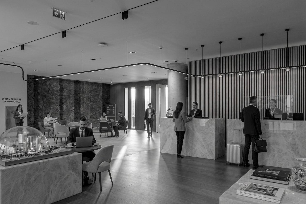 Hotel lobby with business travelers checking in and working, unaware of each other